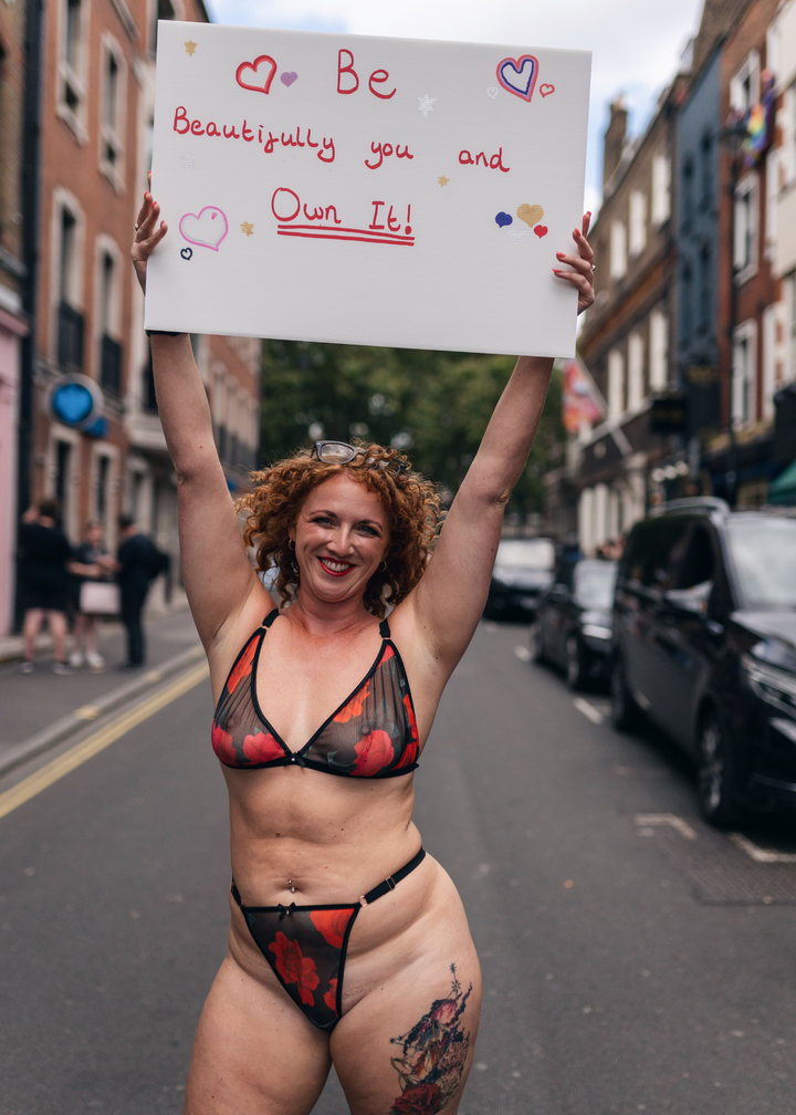 a women in a lingerie set holding up a sign